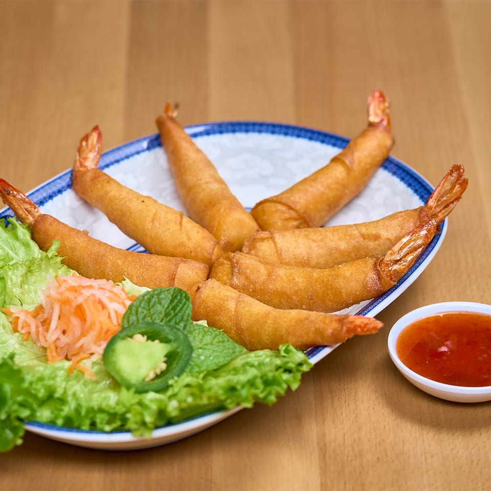 Golden fried shrimp spring rolls with lettuce, pickled vegetables, and sweet chili sauce.