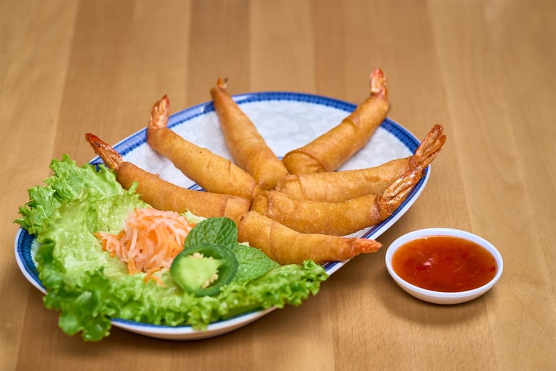 Golden fried shrimp spring rolls with lettuce, pickled vegetables, and sweet chili sauce.